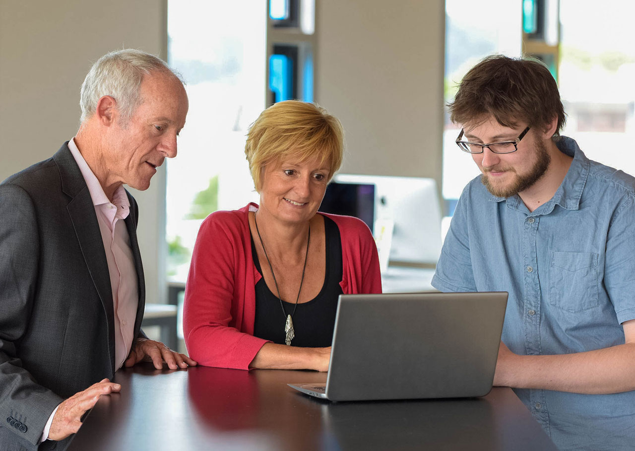 The Accessit team enjoy the easy to use Accessit Library system on a laptop